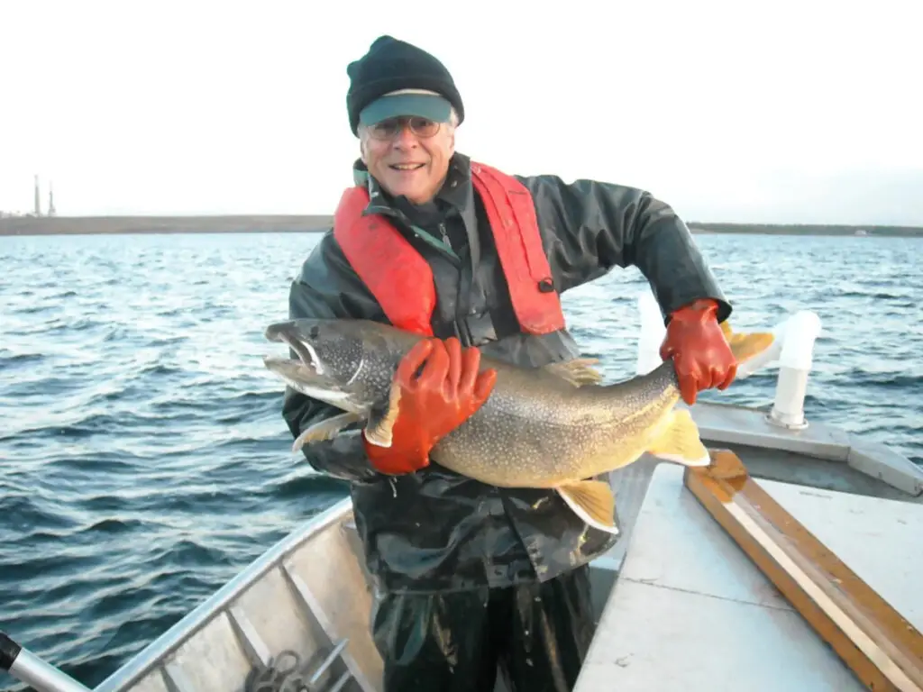 DNR Fisheries Researcher, Jim Johnson, holds Lake Trout during Lake Huron fisheries science survey
