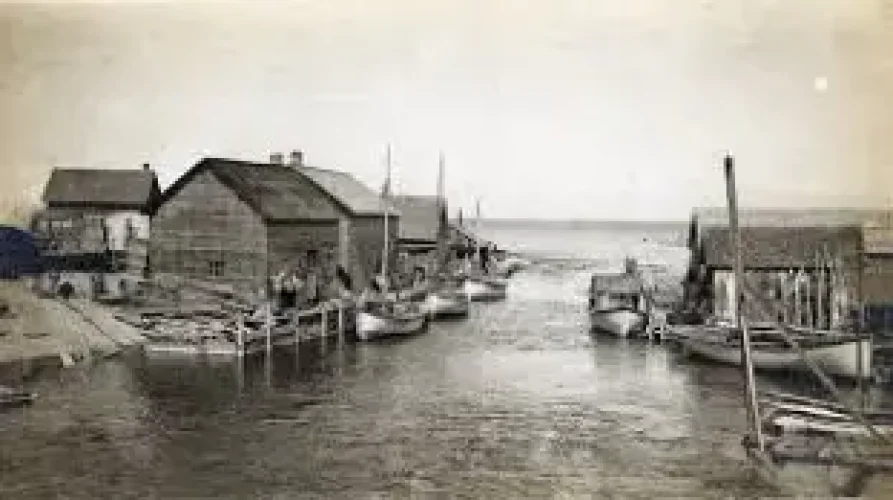 Leland's fleet of Mackinaw Boats in the Leland River., c. 1900.